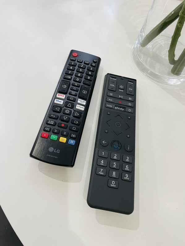 Two remote controls on a white surface.