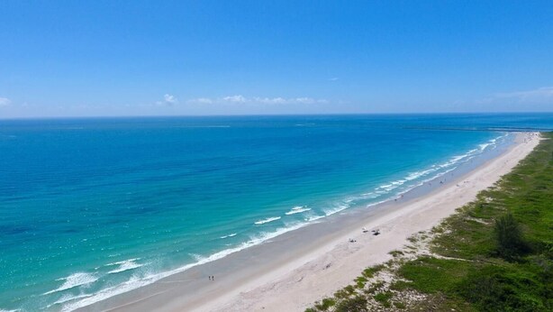 Una playa con aguas turquesas cristalinas y una orilla de arena.