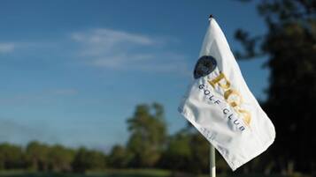 Un drapeau blanc sur lequel on peut lire « GOLF CLUB » et qui arbore un logo, fixé sur un mât.
