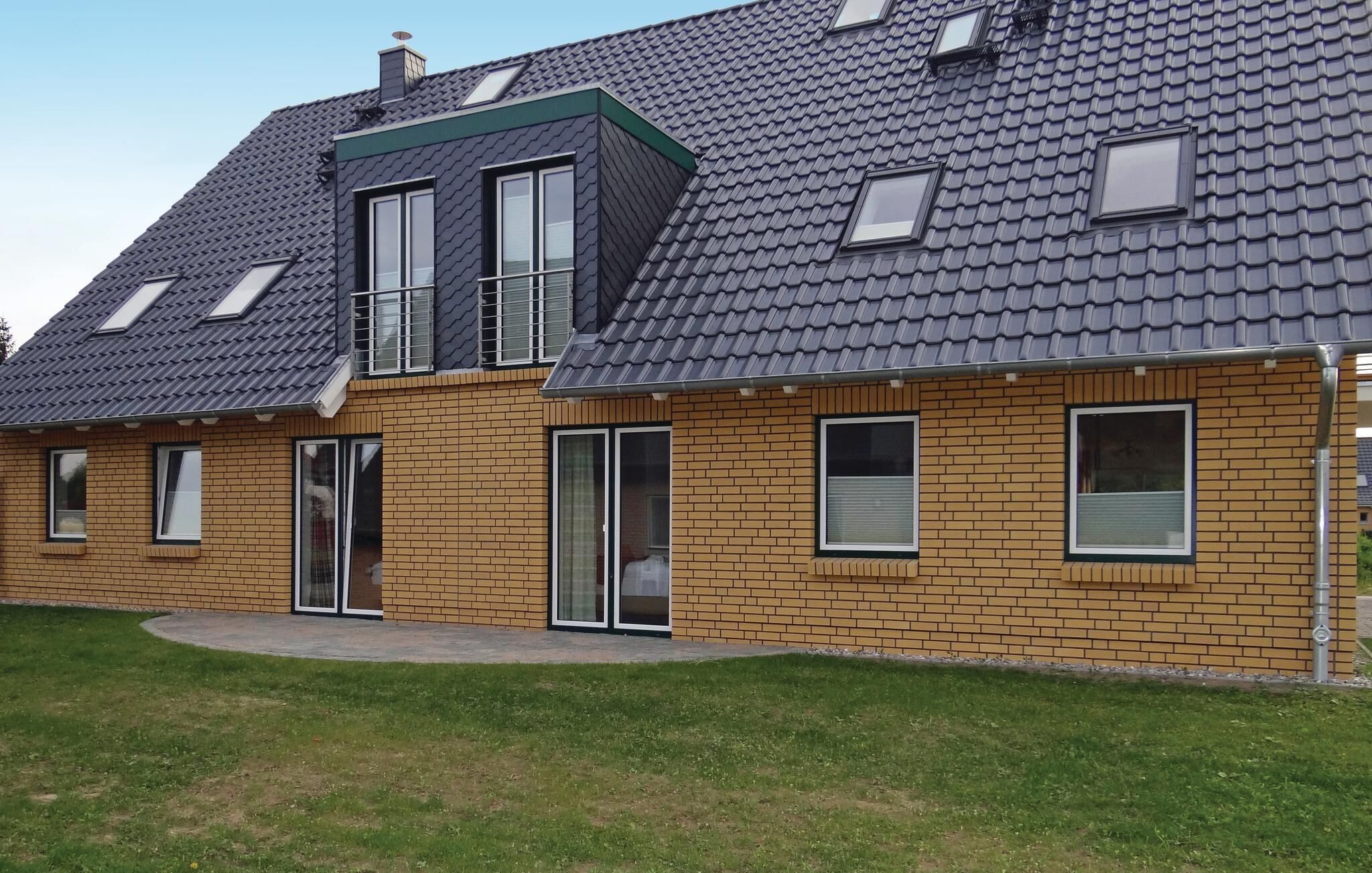 A two-story house with a sloped roof, brick exterior, and multiple windows.