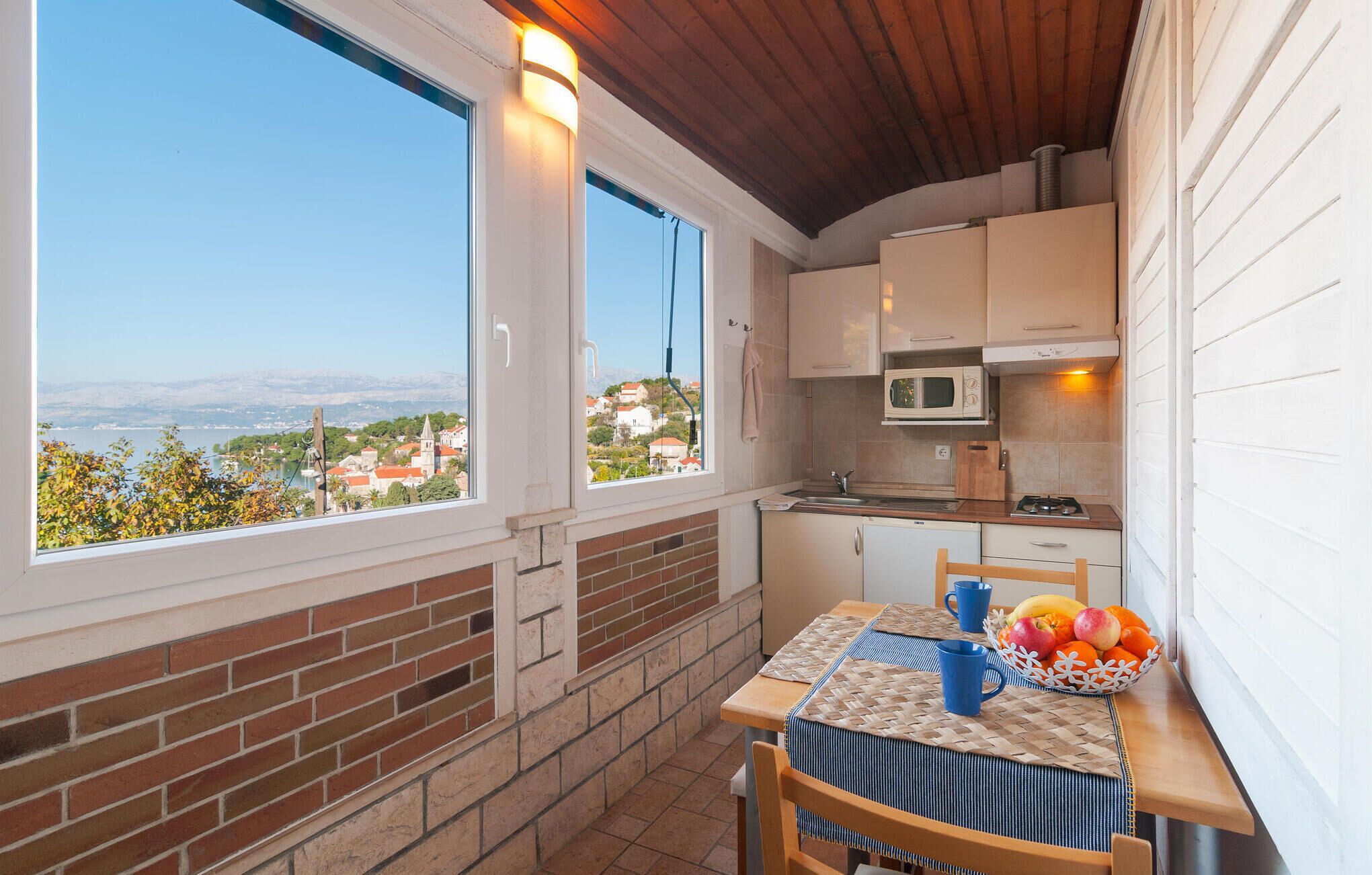 Une petite cuisine avec vue sur la ville et les montagnes.
