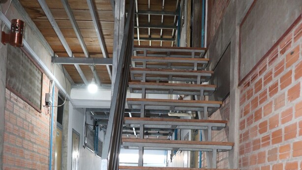 A staircase with metal railings and wooden steps, leading to an upper floor. - Sevenstars Hostel (Sihanoukville)