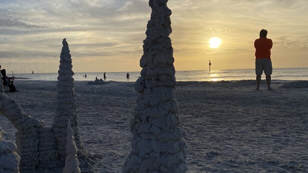 A beach with sand sculptures and a person in the distance. - Luxury and charming 2Bdrm condo, minutes from beautiful Clearwater beach!  (Clearwater)