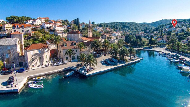 A coastal town with historic stone buildings, a marina with boats, and a clear blue sky. - Stunning apartment in Splitska (Splitska)
