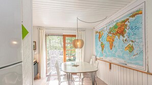 Un espace repas agrémenté d’une grande carte du monde au mur, d’une table ronde et de chaises modernes.