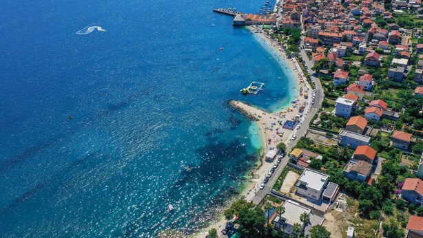 An aerial view of a coastal town with a beach, boats, and a pier. - Awesome apartment in Kastel Stari with house a panoramic view (Kastel Stari)
