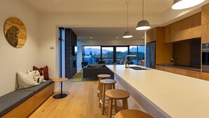 Cocina moderna con una isla grande, armarios de madera y vistas a la montaña.