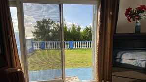 A bedroom with a sliding glass door leading to a backyard. - Blue Diamond Apartments (Warwick Parish)