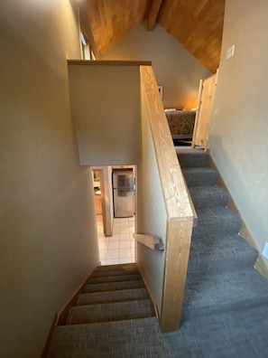 Staircase leads to a cozy living space with a sofa and table.