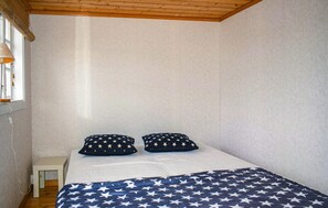 Cozy retreat with a single bed, star-patterned bedding, and a simple nightstand.