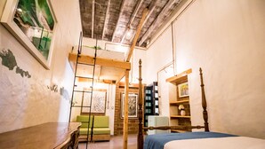A bedroom with a four-poster bed, a green chair, a wooden dresser, and a brick wall. - Mechudo Brewinn (La Paz)