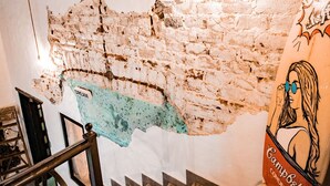 A staircase with a rustic brick wall, a metal railing, and a wall-mounted sign. - Mechudo Brewinn (La Paz)