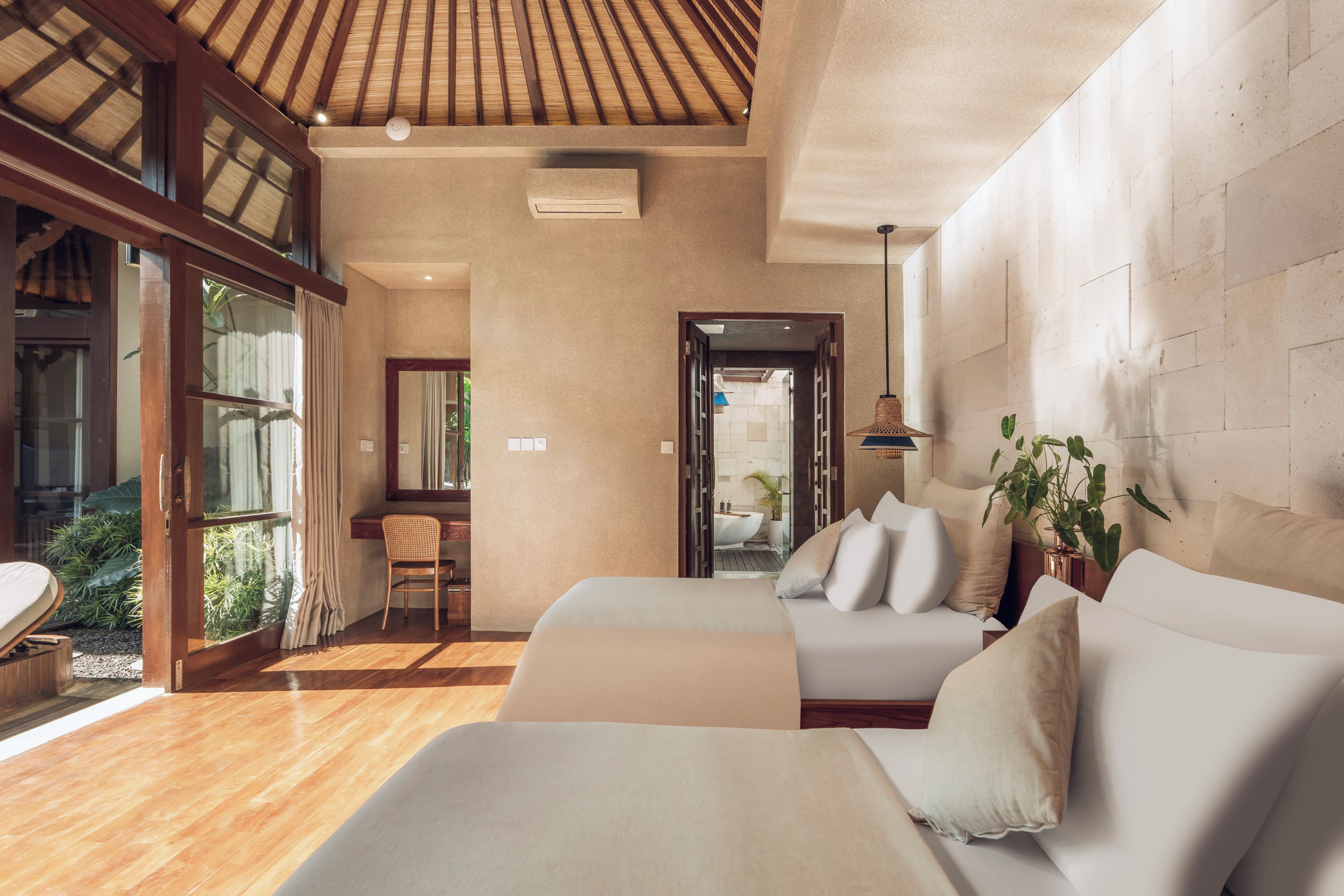 A modern hotel room with a large window, a wooden ceiling, and a view of the garden.