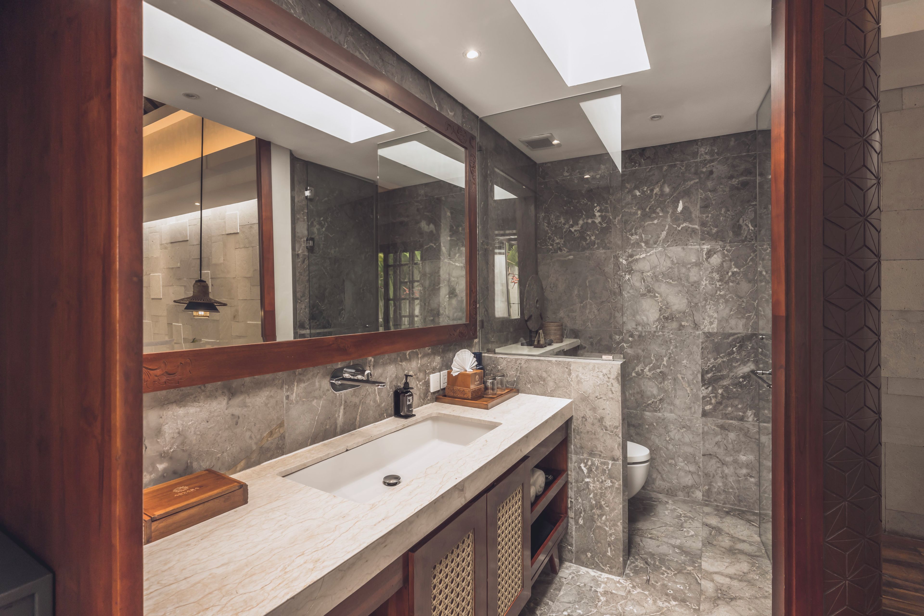 Un baño moderno con un espejo grande, un lavabo doble y una zona de ducha.