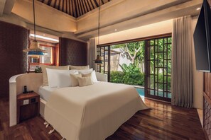 Quarto espaçoso com uma cama grande, mesas de cabeceira, luminária pendente e vista para uma piscina.