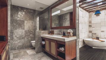 A modern bathroom with a large mirror, two sinks, and a shower area.