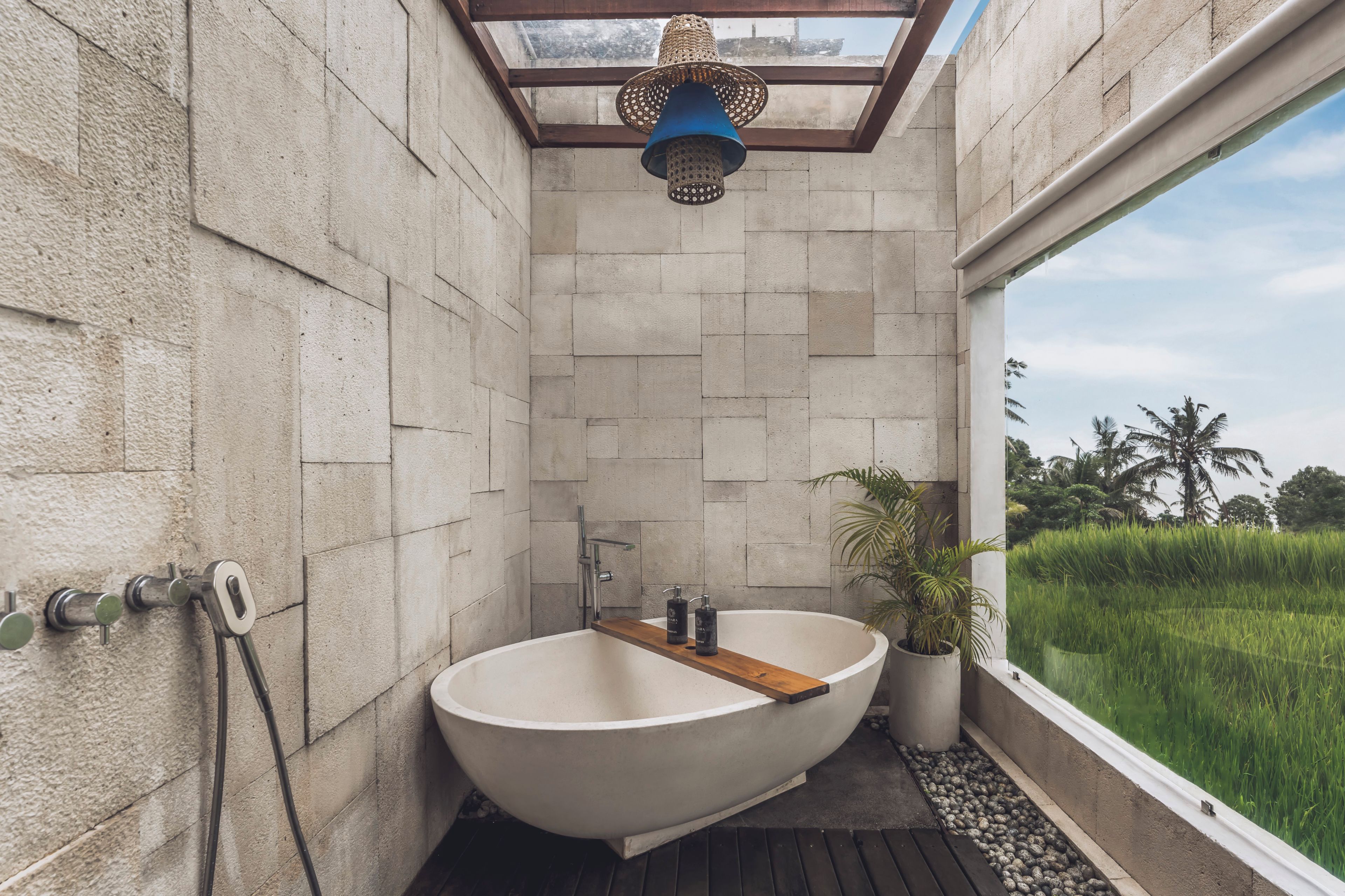 A modern bathroom with a freestanding bathtub, a shower, and a skylight.