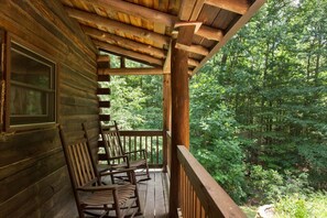A wooden cabin with a porch and rocking chairs. - Sleeps 11! 5BR/2.5BA LRG Log Cabin on 5 Acres, Close to Hendo/AVL, TWO Kitchens! (Hendersonville)