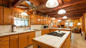 Una cocina amplia con armarios de madera, una isla central y un ventilador de techo.