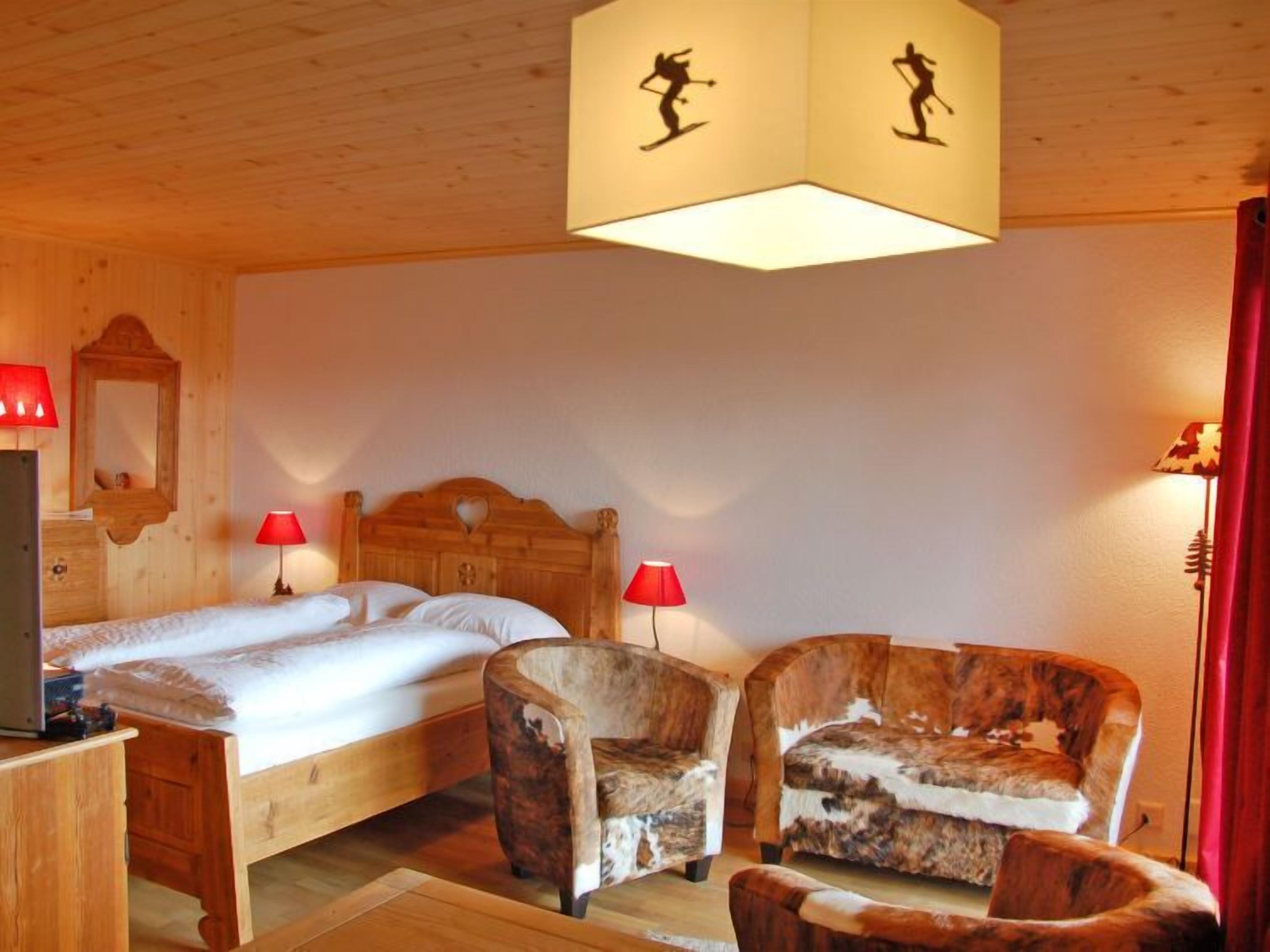 Ein Zimmer mit Holzboden, zwei Betten, einem Schreibtisch und zwei Stühlen.