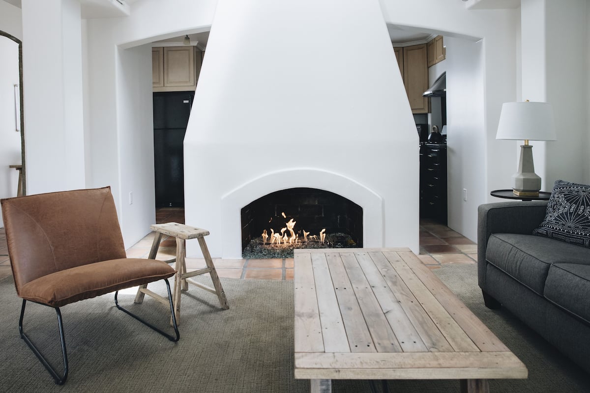 A living room with a fireplace, a sofa, a coffee table, and a chair.