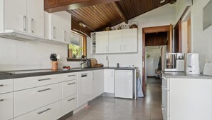 A modern kitchen with white cabinets, a built-in oven, and a coffee machine. - Beautiful home in Vordingborg with WiFi (Vordingborg)