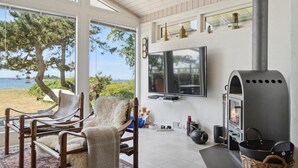 A cozy living room with a large TV, a fireplace, and a view of the sea. - Beautiful home in Vordingborg with WiFi (Vordingborg)