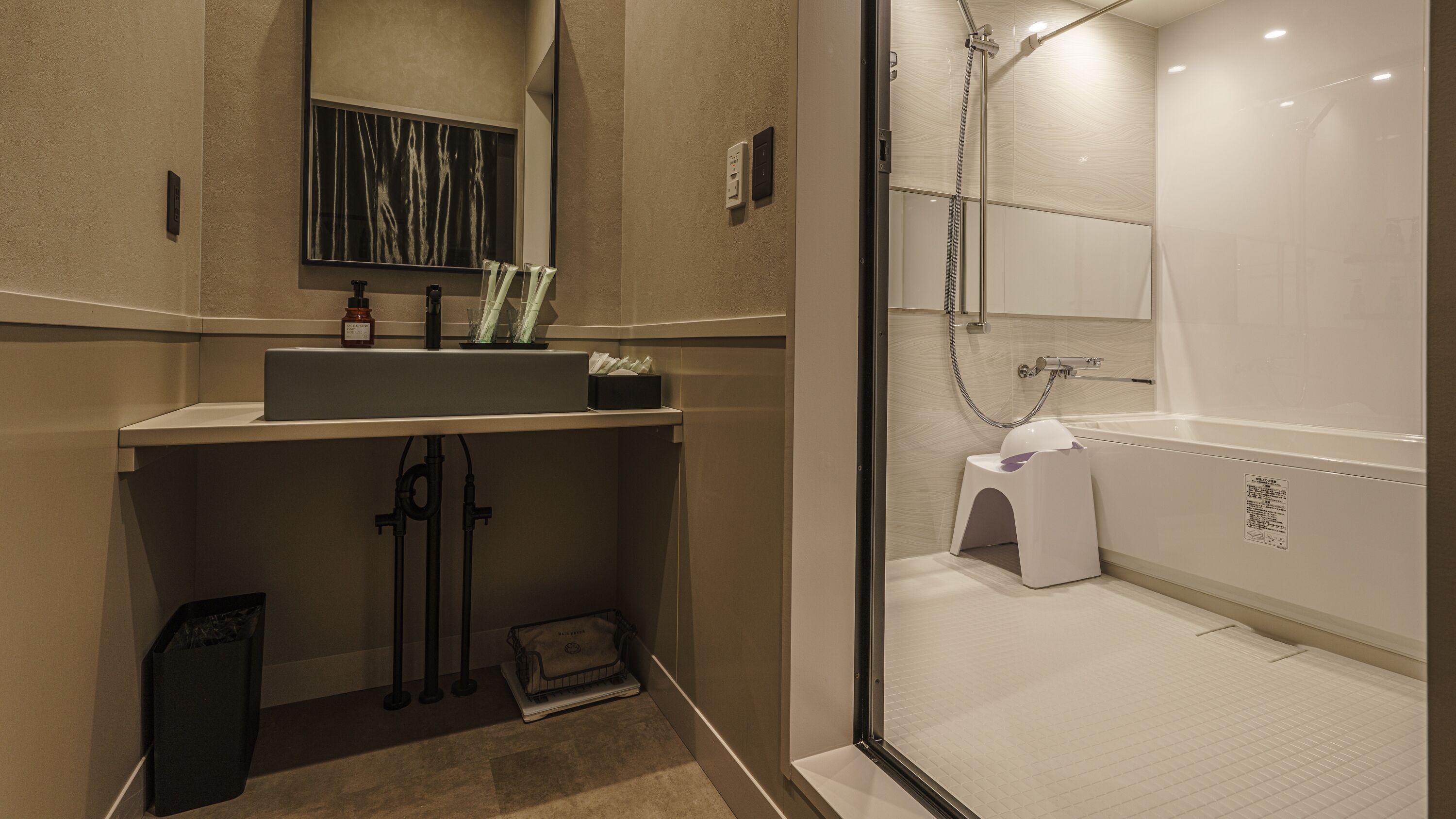A modern bathroom with a sink, mirror, and shower.