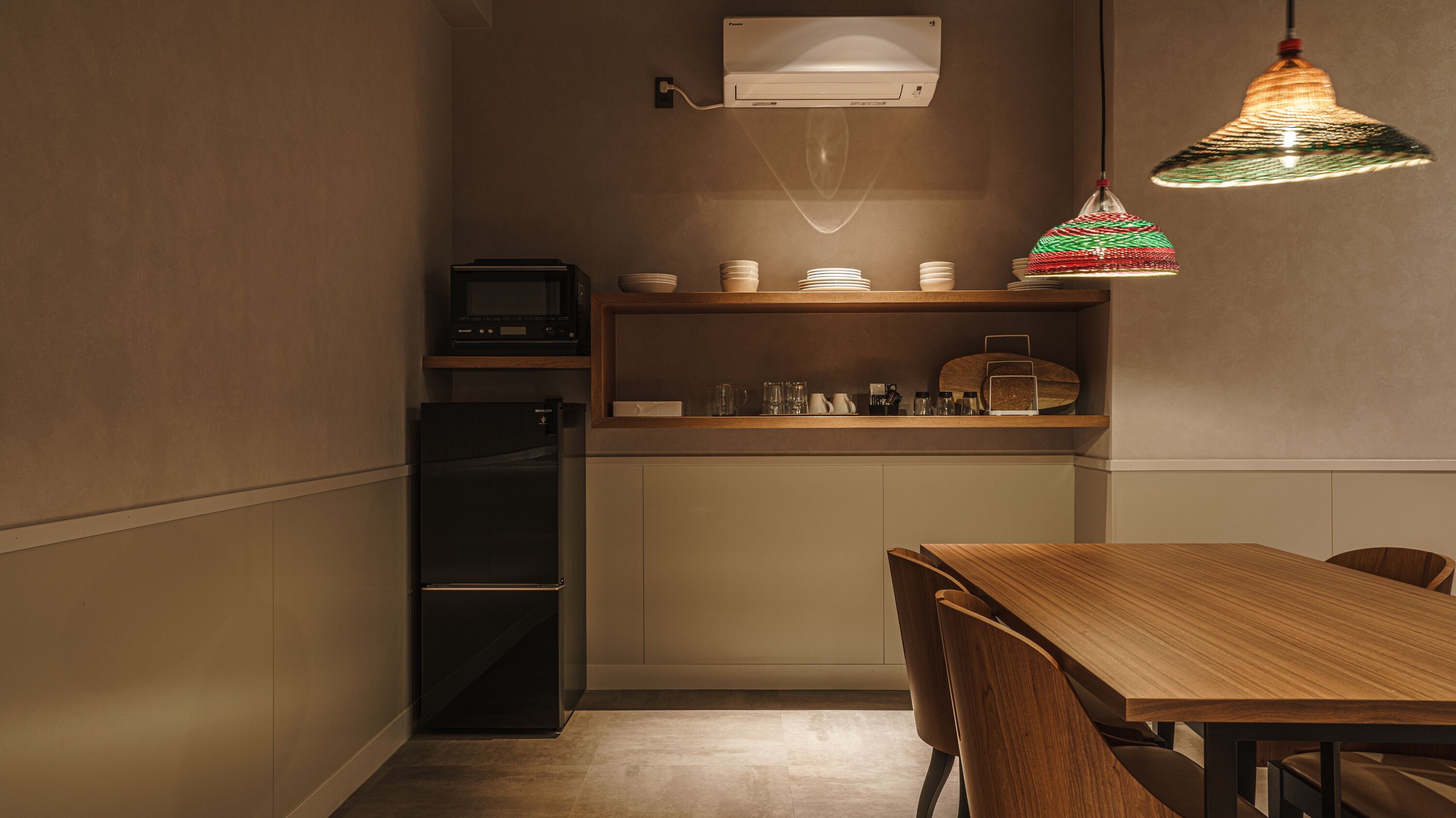 Eine kleine Küche mit Kühlschrank, Mikrowelle und Holzböden.