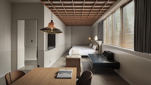 A modern hotel room with a wooden ceiling, a dining table, a sofa, and a bed. - Hotel Aoka Kamigoto (Shinkamigoto)
