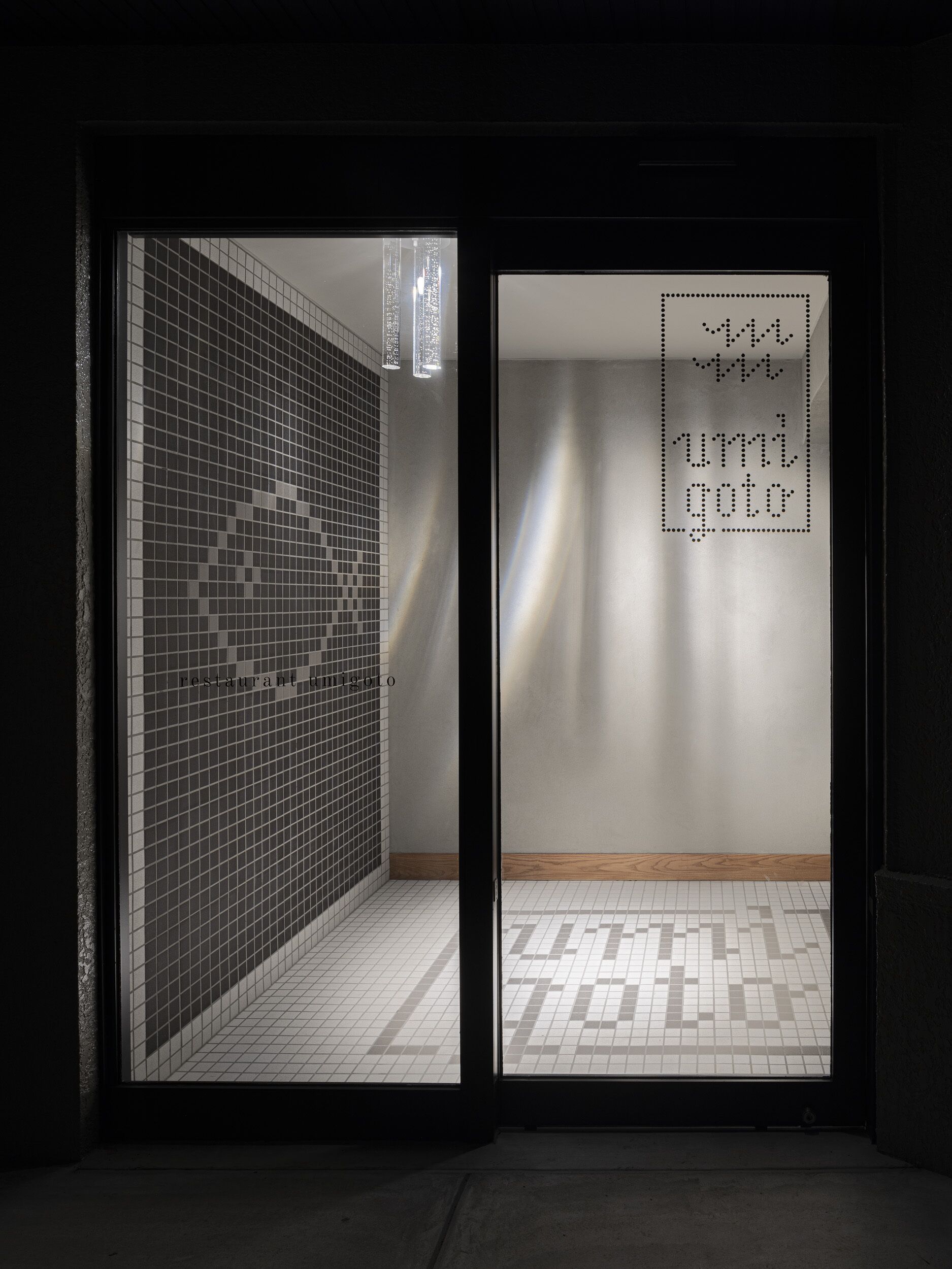 Un intérieur moderne avec un mur recouvert de carreaux et un sol orné d’un motif géométrique.