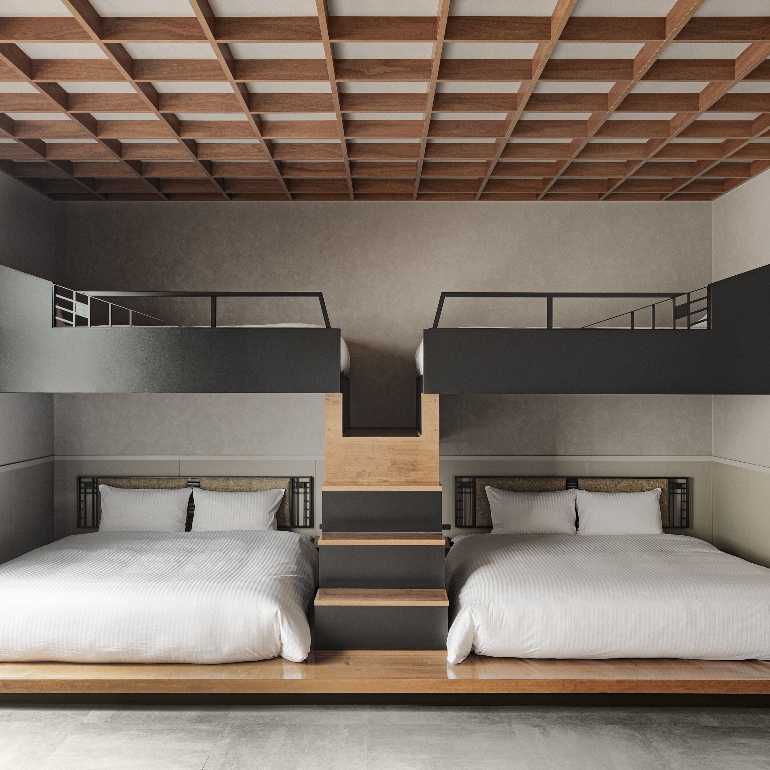 Een moderne slaapkamer met twee stapelbedden, een houten plafond en een neutrale kleurenschaal.