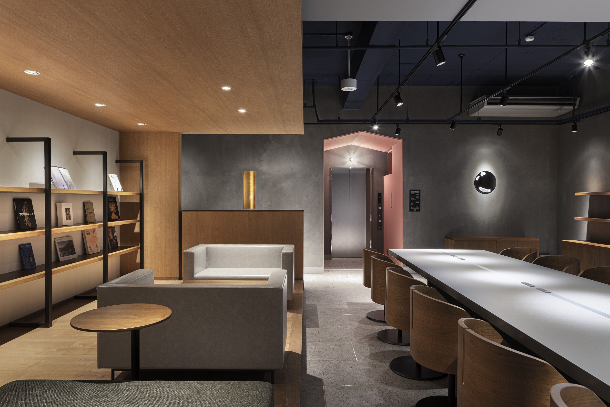 A modern interior with a reception desk, seating area, and a long counter.