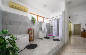 Ein modernes Badezimmer mit Badewanne, Dusche und Waschbecken.
