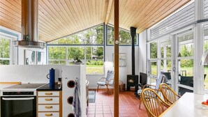 Una cocina con estufa, horno y comedor con sillas y una mesa.