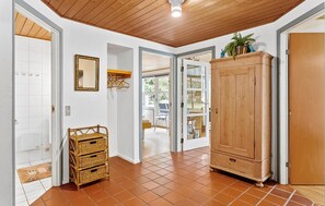 Stylish hallway with a large wardrobe, wicker storage, and ornate mirror.