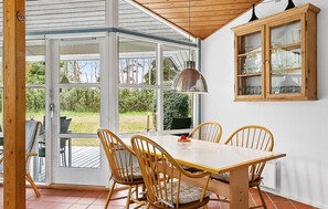 Enjoy meals in this cozy dining area with a wooden table and comfortable seating for four, surrounded by a beautiful view of the outdoors.