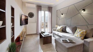 A modern living room with a sofa, coffee table, and a TV mounted on the wall. - Thessaloniki Historic Center - Metro Apartment (Thessaloniki)