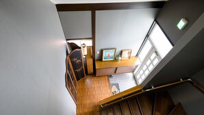 A staircase with wooden steps and a handrail, leading to a room with a wooden floor, a desk with a chair, and a window with natural light. - Cozy Vacation Stay Fuji Kawaguchiko (Fujikawaguchiko)