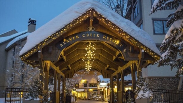 Der Eingang zum Beaver Creek Resort mit schneebedecktem Dach und beleuchteten Lichtern.