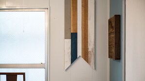 Ein Zimmer mit weißer Wand, einer Holztür mit Kreuz und einem Holzpaneel an der Wand.