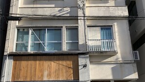 Ein mehrstöckiges Gebäude mit einem Holzladen im Erdgeschoss namens "Sapporo Pollo".