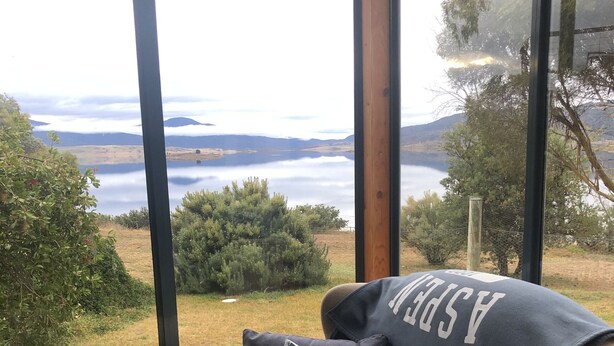 A cozy seating area with a view of a lake and mountains. - Lakefront@Tyrolean House Waterfront EAST JINDABYNE (East Jindabyne)