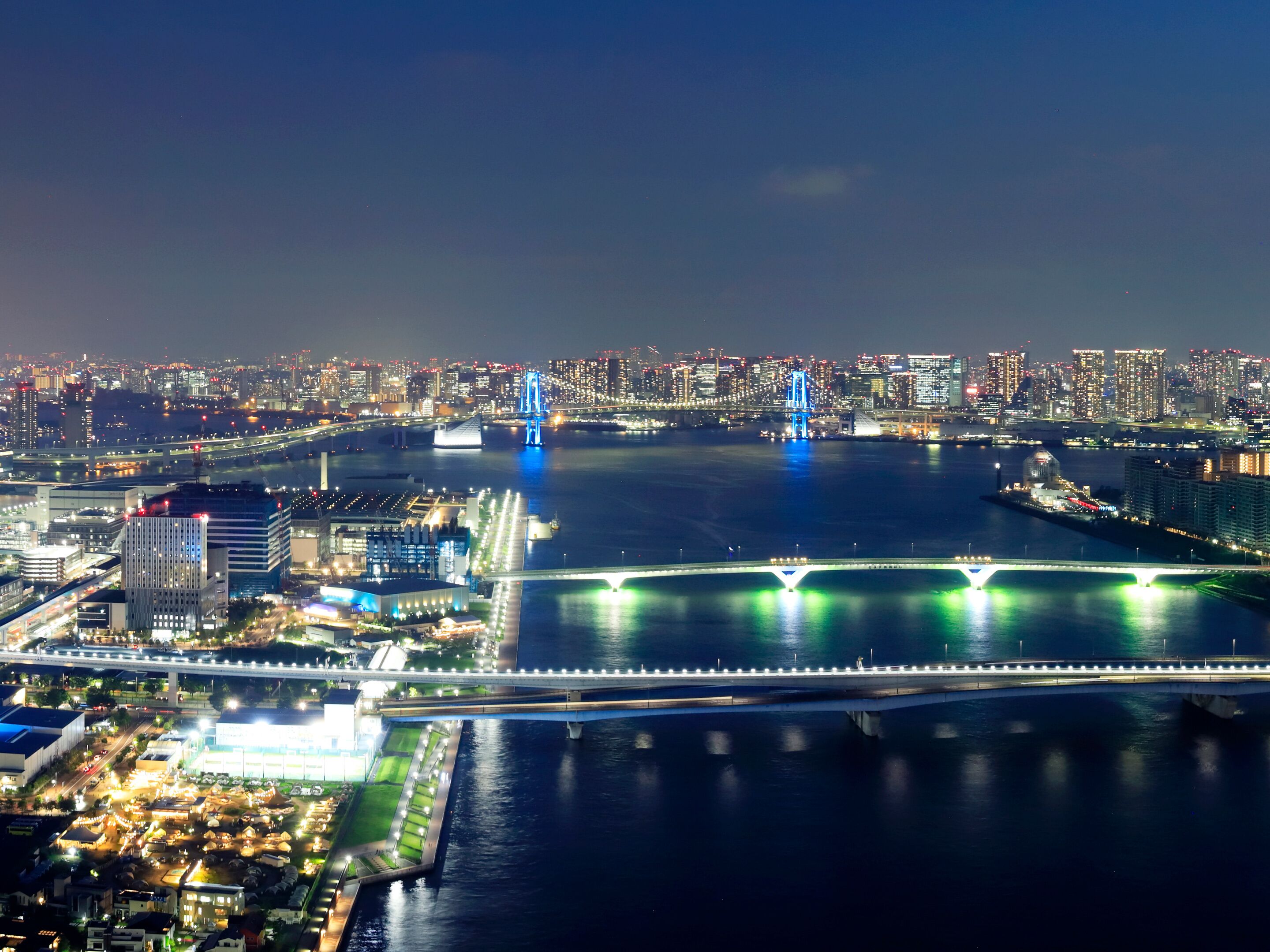 A nighttime cityscape with illuminated bridges and buildings.