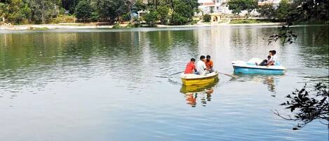 Two boats on a calm lake with buildings in the background.