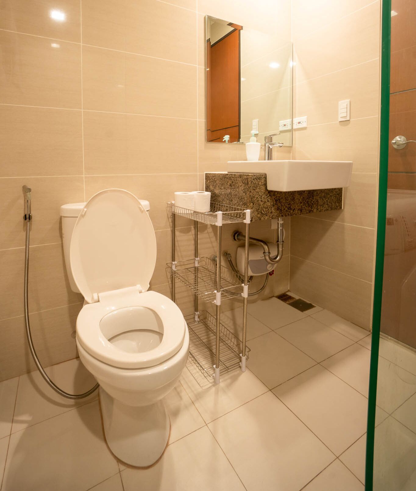 A modern bathroom with a toilet, shower, and sink.