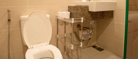 A modern bathroom with a toilet, shower, and sink.