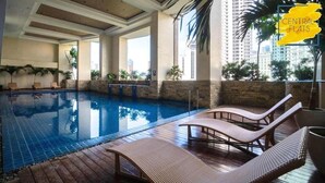 A swimming pool with lounge chairs and a view of tall buildings. - KL Tower - PH Staycation (Makati)