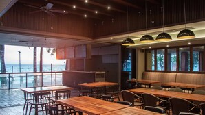 A restaurant with wooden tables and chairs, ceiling fans, and large windows overlooking the sea. - Mandarin White Sand Boracay (Boracay Island)