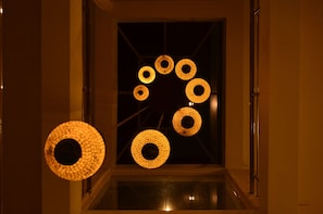 Um corredor com vários luminários circulares no teto.